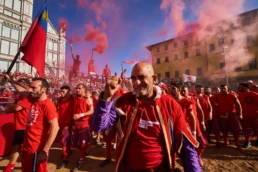 Calcio Storico Fiorentino: supporters in red parade with a flag ahead of the match in Piazza Santa Croce